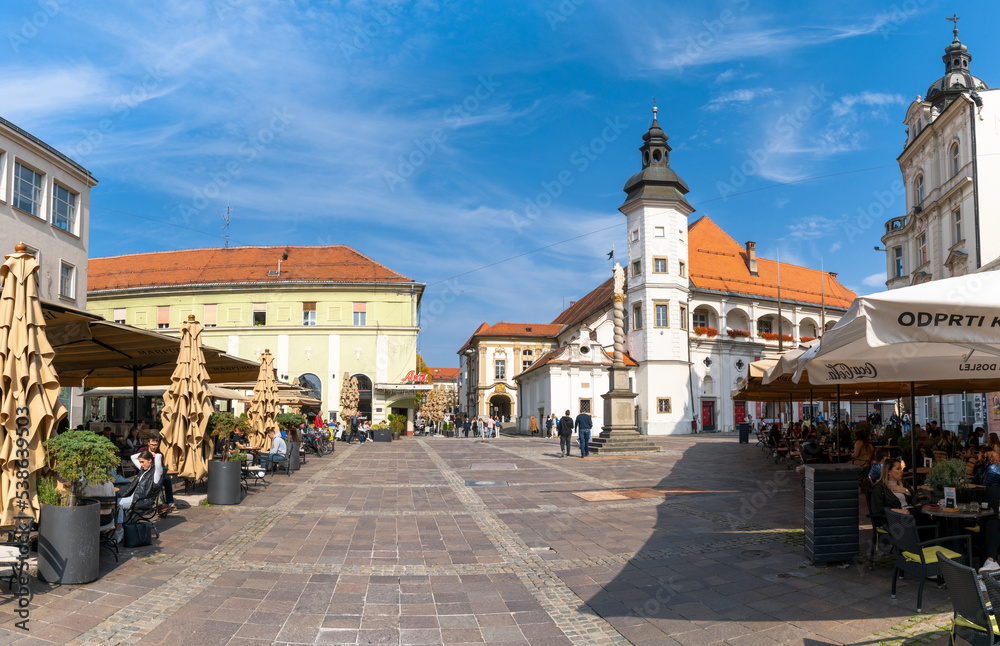 view of the historic city center of Maribor with town square and church and outdoor restaurants