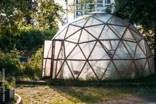 Domestic greenhouse. Cultivate farming. Natural gardening. Cupola hothouse with transparent plastic membrane geometric net frames outdoor daylight. © golubovy