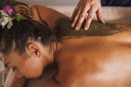 Woman Enjoying Seaweed Mud Massage In Spa Centre