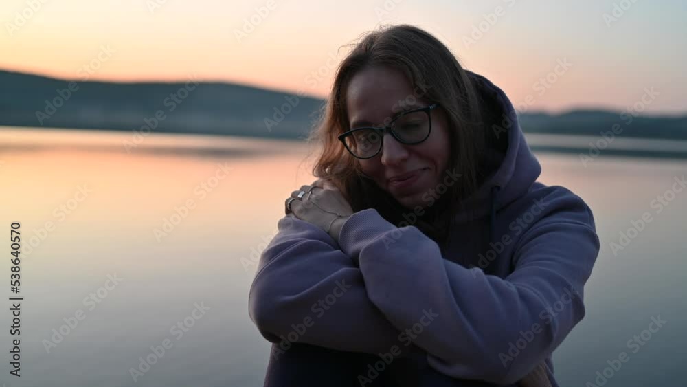 Woman sitting on the pier, closeup portrait, summer sunset Woman sitting on the pier, closeup portrait, summer sunset