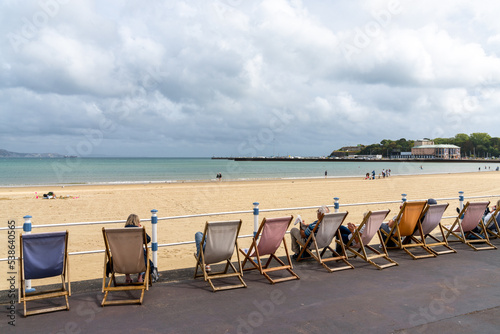 people relaxing in lounge chairs on the esplanade at Weymouth Beach in Dorset photo