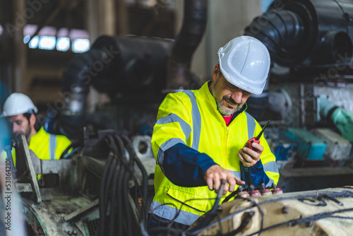 professional technician engineer working to check safety system of heavy industry manufacturing machine in construction plant and service a factory equipment of production job technology