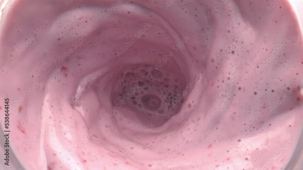 Fruit milk cocktail rotating moving top view. Calcium milkshake making funnel