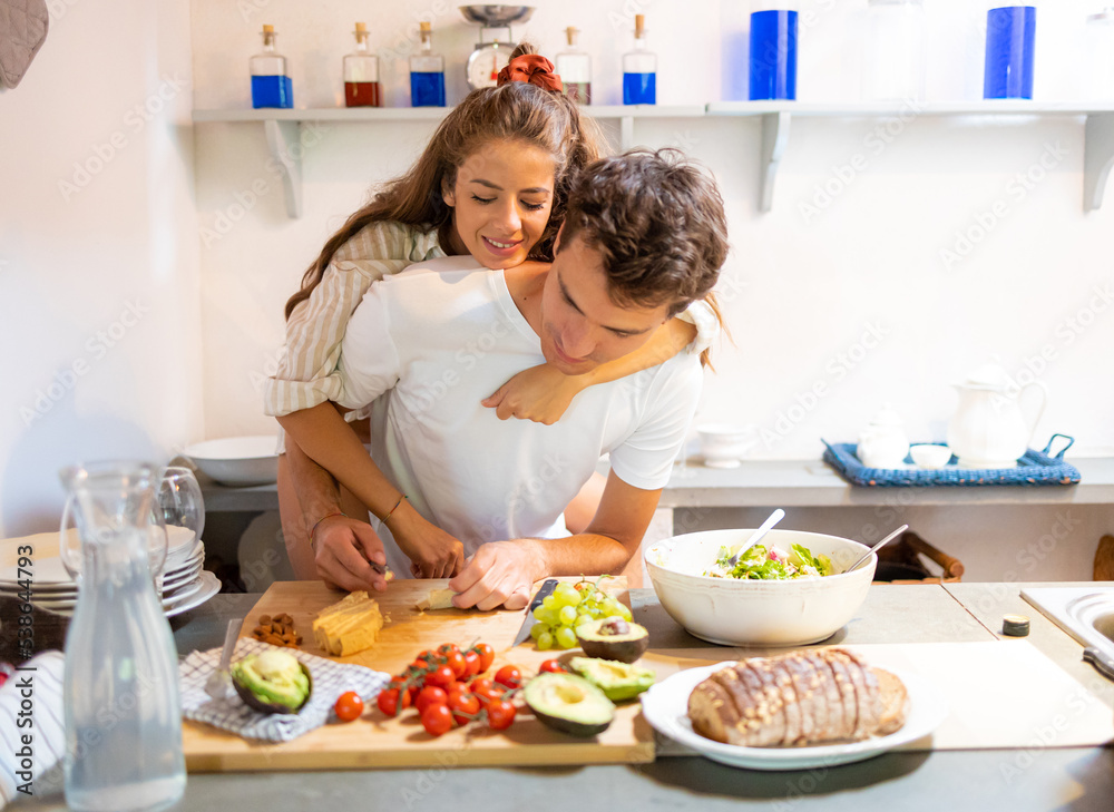 Young couple having fun in the kitchen in the morning, while preparing breakfast