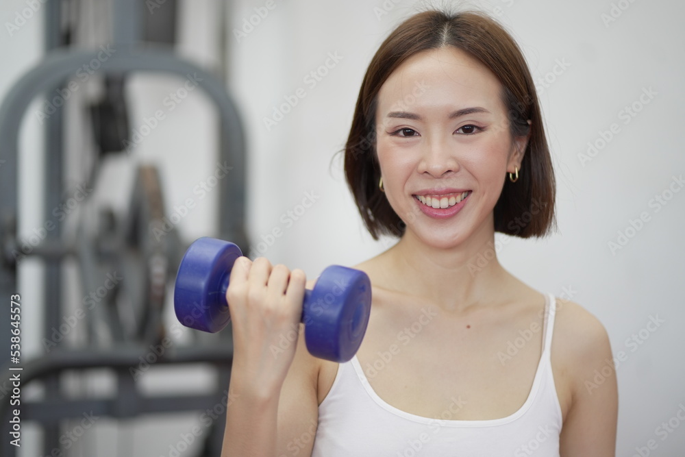 Asian Sports women in gym.Portrait of fitness young woman in sports clothing exercising on cardio machine at gym.