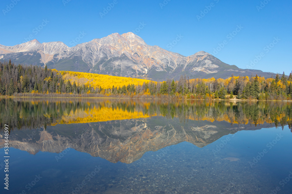 autumn in the mountains, with perfectly calm lake reflecting mountains above