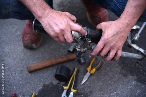 Male hands of a car mechanic with tools in outdoor work