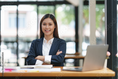 Asian entrepreneur making business plan while working on laptop with empty screen