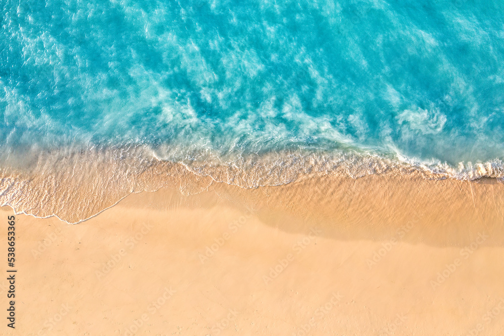Summer seascape beautiful waves, blue sea water in sunny day. Top view from drone. Sea aerial view, amazing tropical nature background. Beautiful bright sea waves splashing and beach sand sunset light - obrazy, fototapety, plakaty 