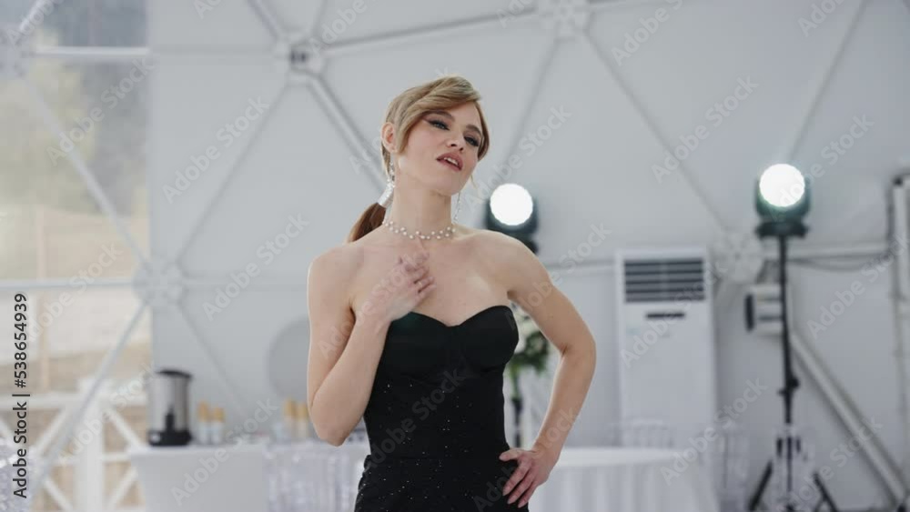The model looks into the camera at a fashion show. The model looks into the camera at a fashion show.