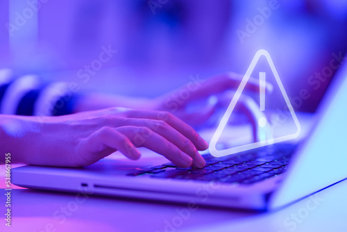 Businesswoman using computer laptop with triangle caution warning sing for notification error and maintenance concept.