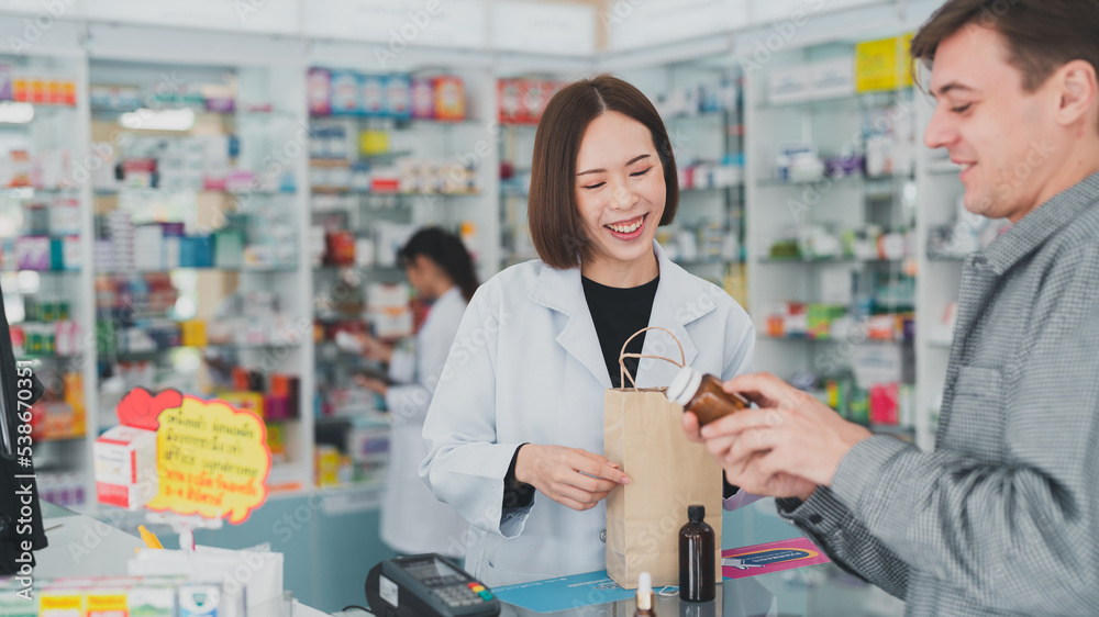The doctor prescribes the pills according to the customer  prescription.Female pharmacist with medical expertise.Business, pharmacy, professional health care.An adult doctor smiling at a drugstore.