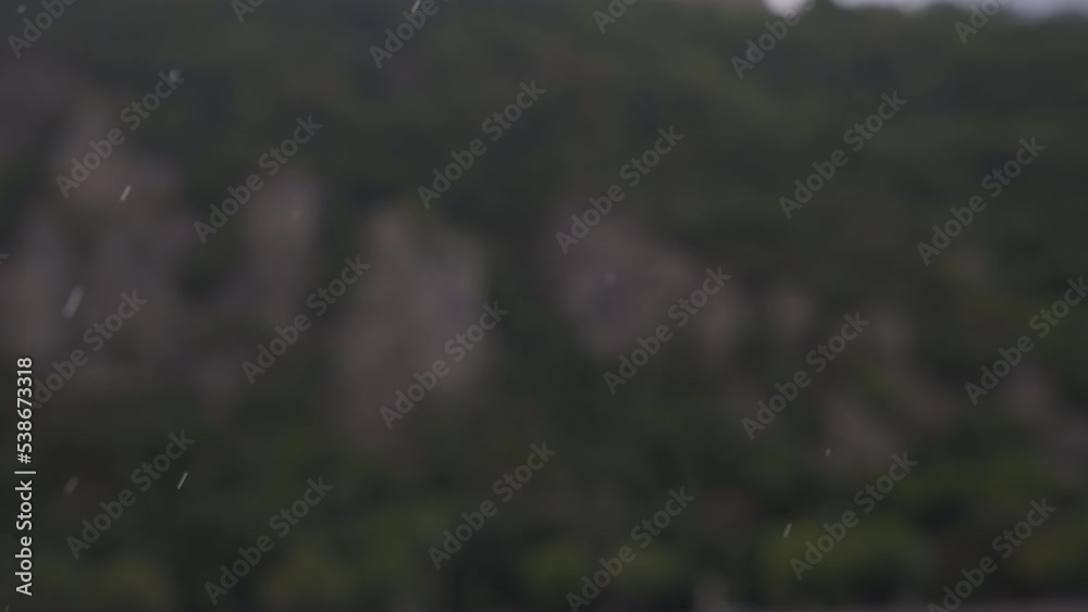 Raindrops falling against the mountain blurry background. Slow motion. Raindrops falling against the mountain blurry background. Slow motion.