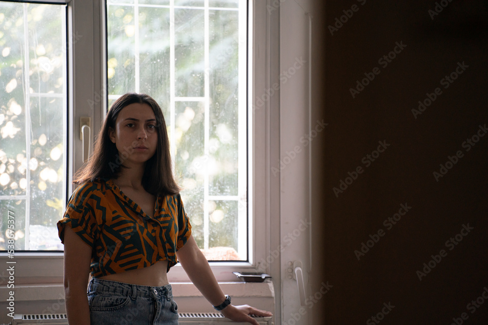 sad woman waiting someone in front of window