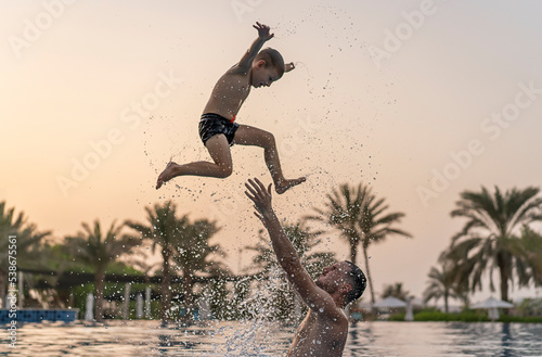 Photography Dad and son are playing in the swimming pool