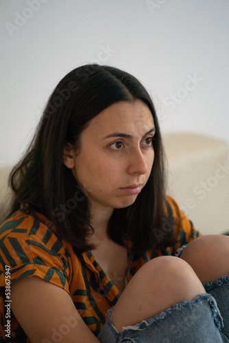 sad woman sitting on the couch © serkan