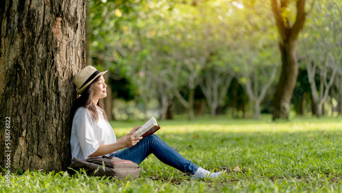A beautiful Asian woman Enjoying and relax from reading book outdoor