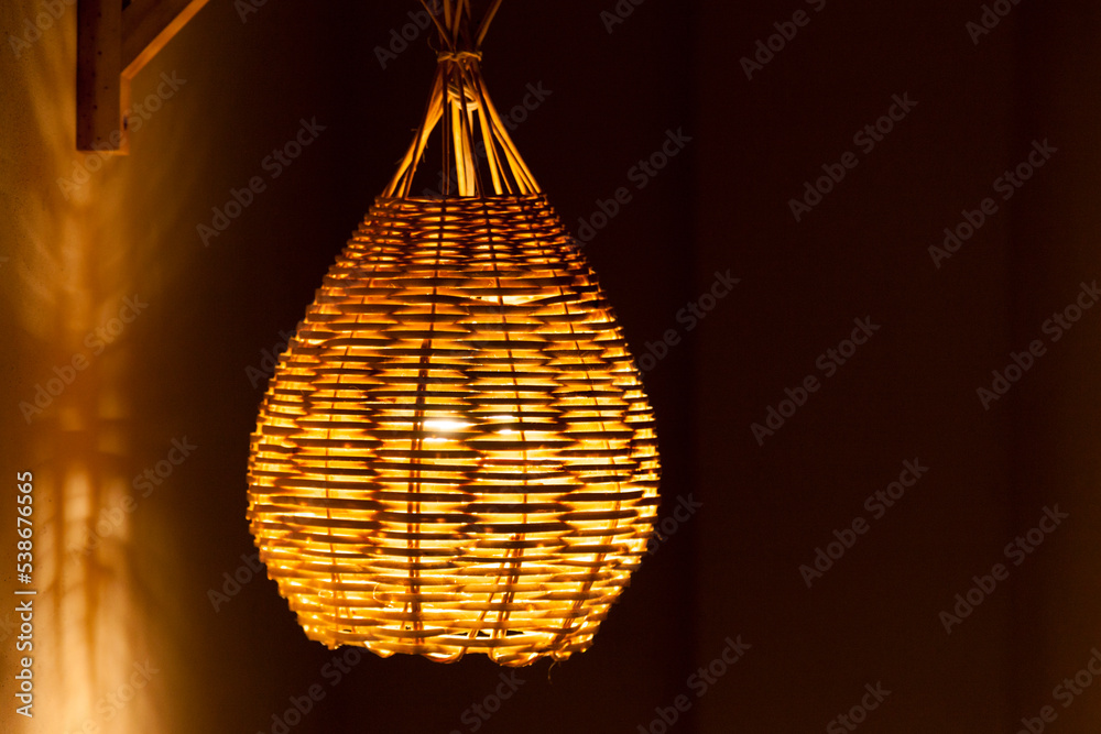Pendant luminaire for outdoor area with yellow light. Handmade lamp made of straw. Luminaire concept. Home sweet home concept. Pendant luminaire for outdoor area with yellow light. Handmade lamp made of straw. Luminaire concept. Home sweet home concept.