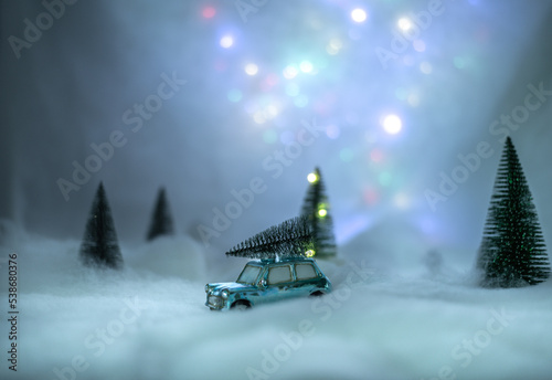toy car with a christmas tree on top in a illumated winter scene at night photo