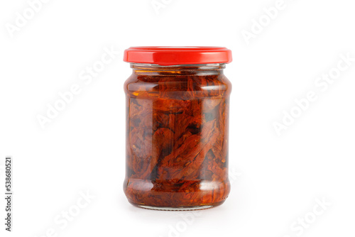 Sun dried tomatoes with olive oil in glass jar isolated on a white background, clipping path, cut out. Sun-dried tomatoes, preserves. photo