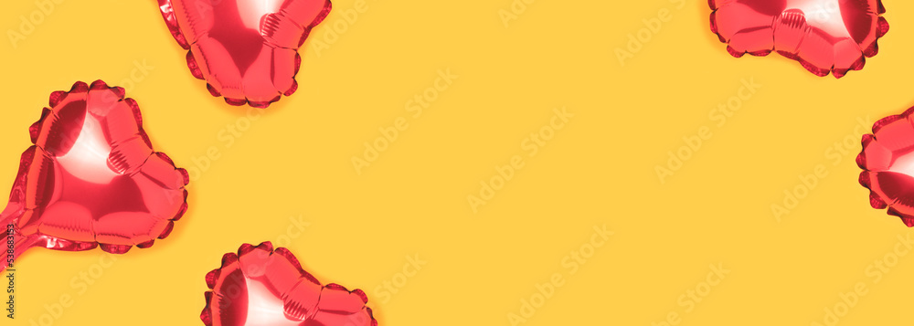 Banner with red hearts foil balloons. Cute composition on a yellow background with copy space. Banner with red hearts foil balloons. Cute composition on a yellow background with copy space.