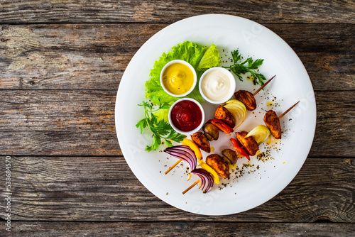 Chicken skewers - grilled meat with vegetables on wooden background 