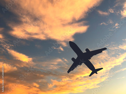 Silhouette of a passenger cimbing after take off againsts a sunset sky. No people. Copy space.