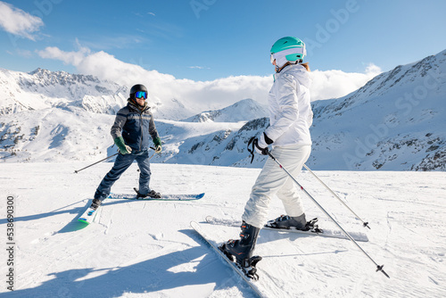 Student and ski teacher on pist in the snow