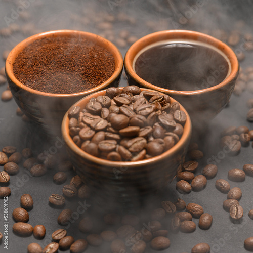 Freshly ground and prepared black coffee on a black background.