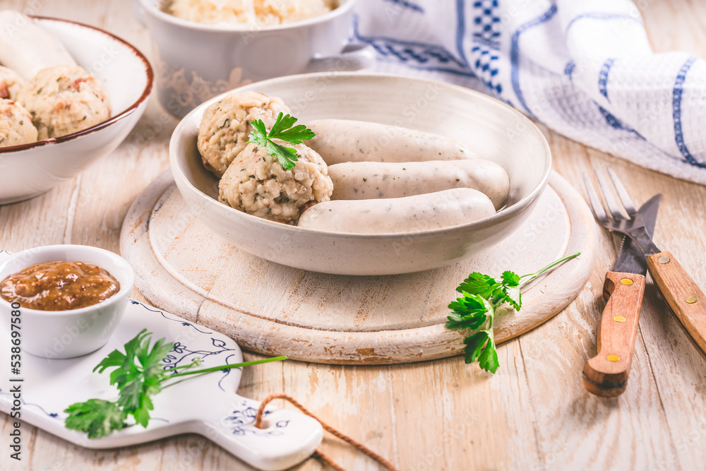 White veal sausage (Weisswurst) with pickled white sour cabbage (Sauerkraut) and bread dumplings (Knodel) White veal sausage (Weisswurst) with pickled white sour cabbage (Sauerkraut) and bread dumplings (Knodel)