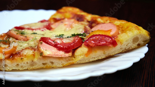 A piece of pizza on a white plate side view. Selective Focus