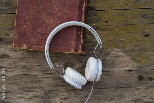 headphones on old book and wooden background