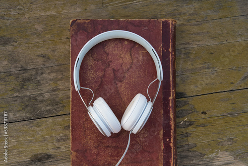 headphones on old book and wooden background