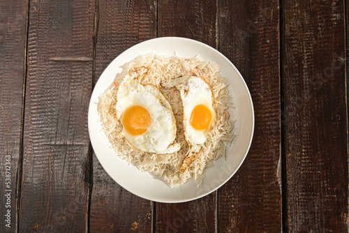 rice dish with fried egg on brown wooden table