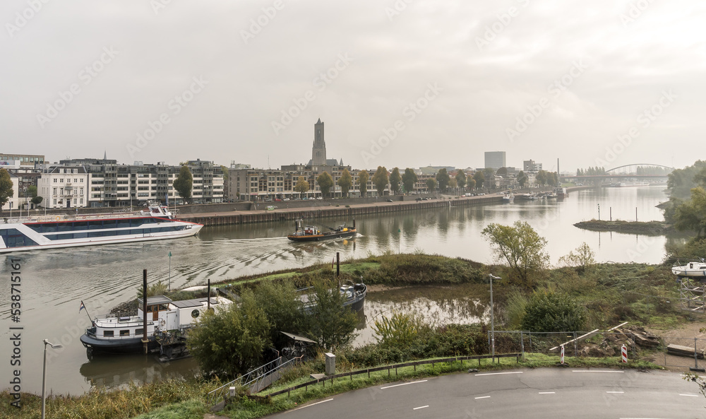 Skyline of the Dutch city Arnhem seen from the bridge over the river Rhine on an overcast day