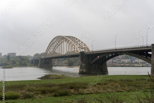 Historic bridge named "Waalbrug" over the river Waal  by Nijmegen, The Netherlands on a morning with overcast sky © Mike Wiering