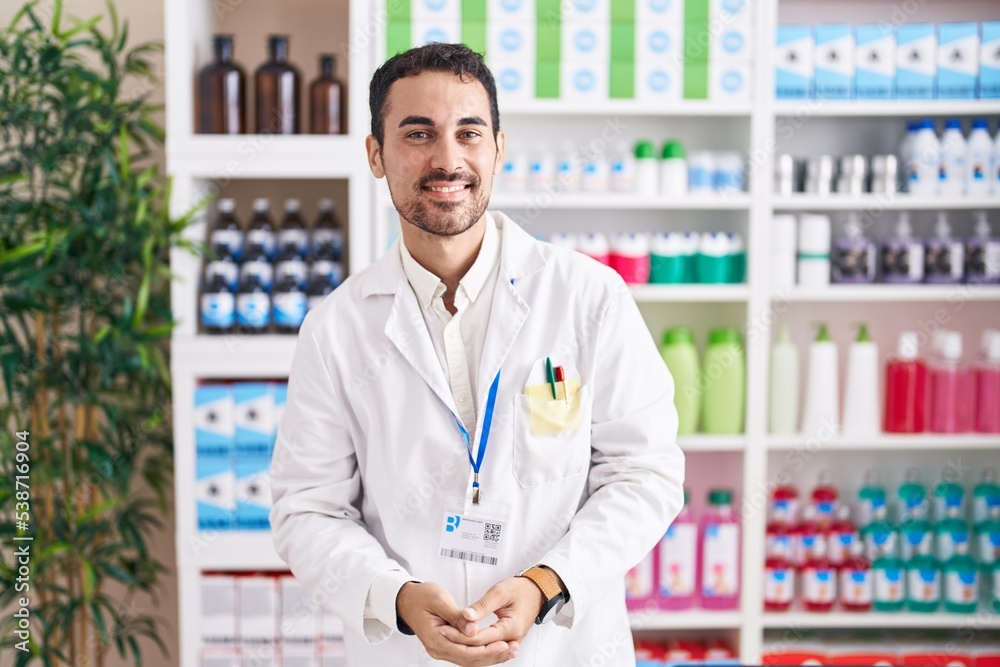 Handsome hispanic man working at pharmacy drugstore with hands together and crossed fingers smiling relaxed and cheerful. success and optimistic Handsome hispanic man working at pharmacy drugstore with hands together and crossed fingers smiling relaxed and cheerful. success and optimistic