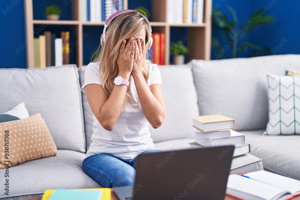 Young blonde woman studying using computer laptop at home rubbing eyes for fatigue and headache, sleepy and tired expression. vision problem