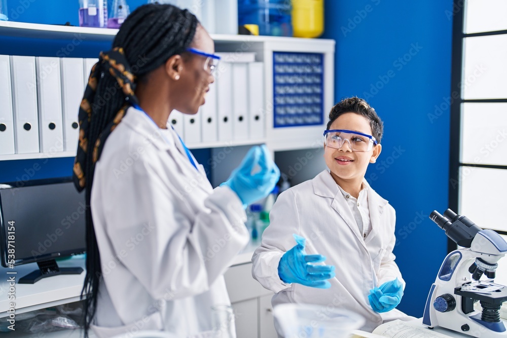 African american mother and son scientists smiling confident speaking laboratory
