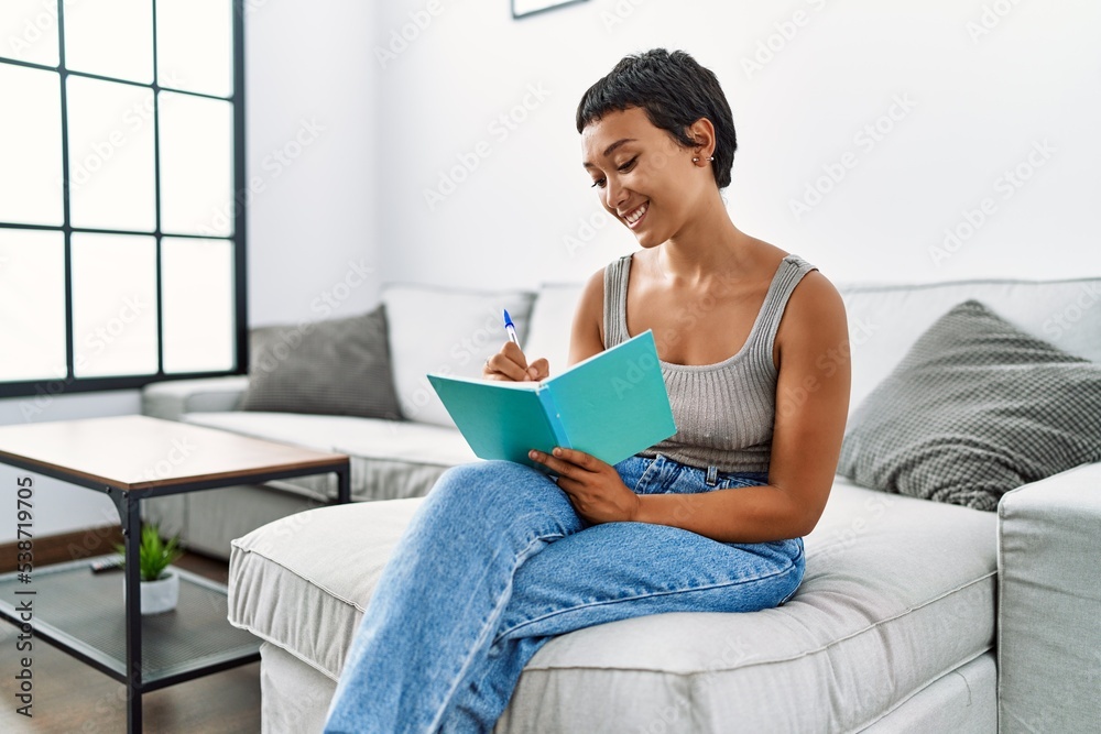Young hispanic woman smiling confident writing on notebook at home Young hispanic woman smiling confident writing on notebook at home