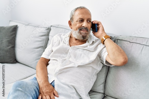 Senior grey-haired man smiling confident talking on the smartphone at home