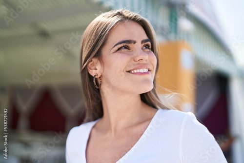 Young woman smiling confident looking to the sky at street