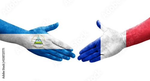 Handshake between France and Nicaragua flags painted on hands, isolated transparent image.