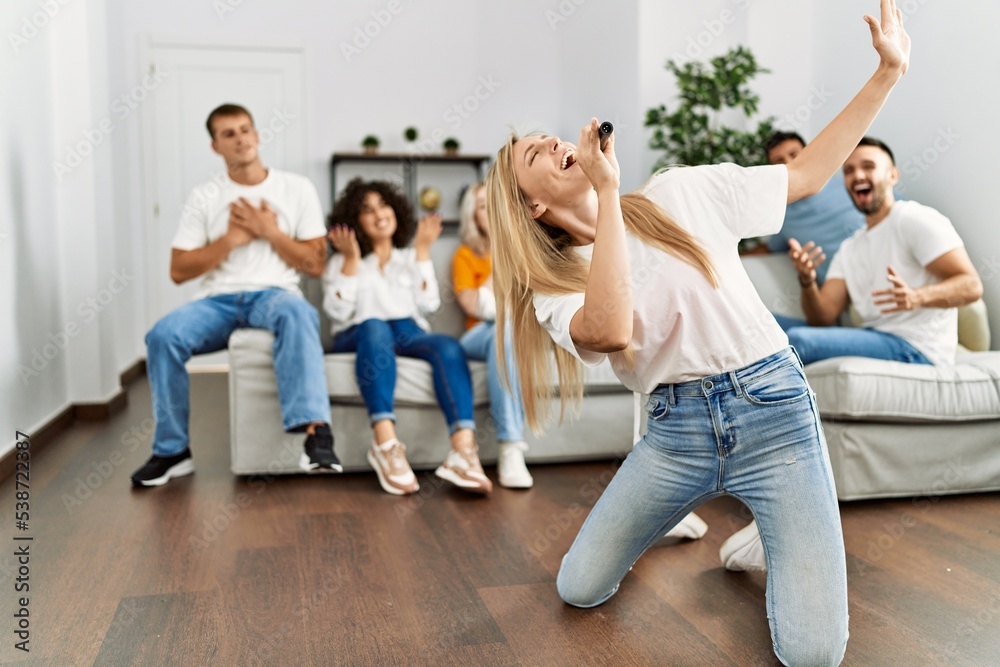 Group of young friends having party singing song using microphone at home. Group of young friends having party singing song using microphone at home.