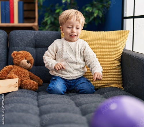 Adorable toddler smiling confident playing with toys at home photo