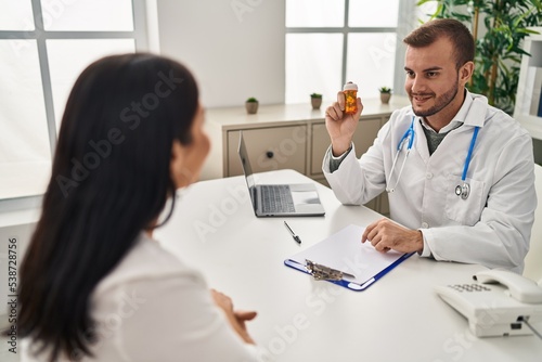 Man and woman doctor and patient having medical consultation prescribe pills at clinic