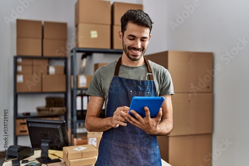 Canvas Print Young hispanic man business worker using touchpad at storehouse