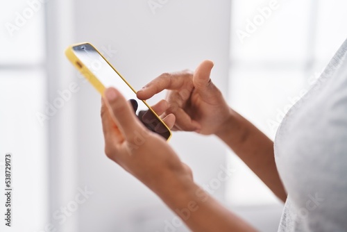African american woman using smartphone standing at home