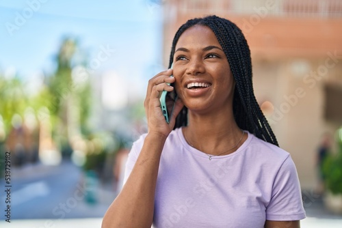 African american woman smiling confident talking on the smartphone at street