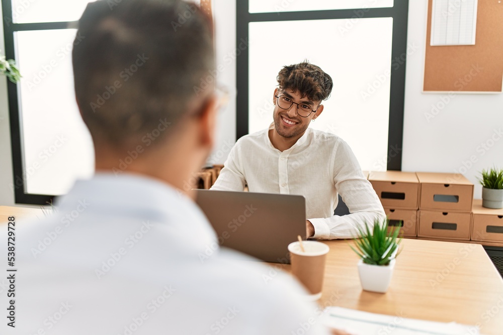 Two hispanic men business workers smiling confident working at office Two hispanic men business workers smiling confident working at office